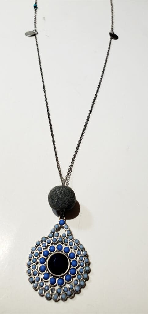Turquoise and black beaded pendant necklace featuring an intricate blue design, showcasing its artistic craftsmanship. Perfect for a stylish accessory.